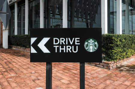AYUTTHAYA, THAILAND - April 14, 2021: Drive thru sign of Starbuck Coffee shop. It is an US global coffee company, the largest coffeehouse company in the world on Highway at AYUTTHAYA, THAILAND.のeditorial素材