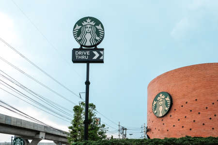 AYUTTHAYA, THAILAND - April 14, 2021: Drive thru sign of Starbuck Coffee shop. It is an US global coffee company, the largest coffeehouse company in the world on Highway at AYUTTHAYA, THAILAND.のeditorial素材