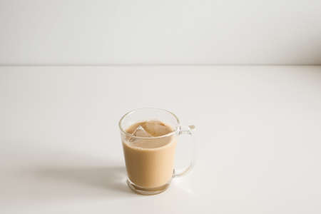 Ice coffee with milk on a white wood table and refreshing look of the drink, with a clean white...