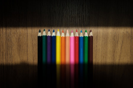 Colored pencils background. Color pencils with shadow on wooden backgroundの写真素材