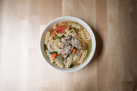 hot meat soup with vegetables and pasta on wooden background, Delicious healthy foodの写真素材