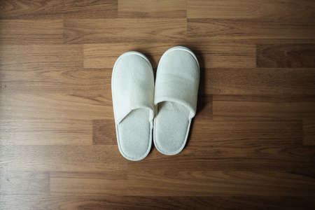 White slippers on wooden background with empty space, top view image.