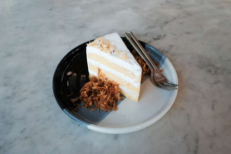 A fresh piece of coconut cream cake, Coconut layer cake slice on a plateの写真素材