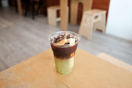 iced americano black coffee and layer of fresh sugarcane juice in glass decorated with sugarcane on...