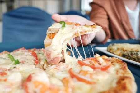 Happy business team eating pizza have lunch in the restaurant.の写真素材