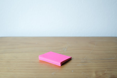 Blank pink sticky note block on desk, selective focus.の写真素材