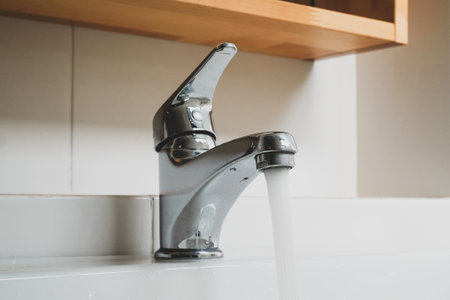 Running water tap, Interior of bathroom with sink basin faucet, Open chrome faucet washbasin, Modern...