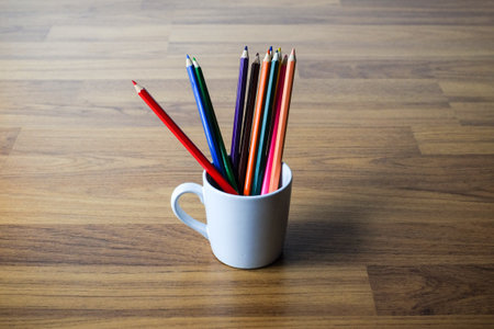 Stack of colored pencils in a glass on wooden background, Selective focus.の写真素材