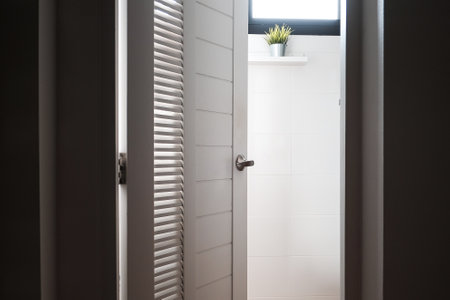 <p>Metal door knob with lock close-up on white wooden door.</p>の写真素材