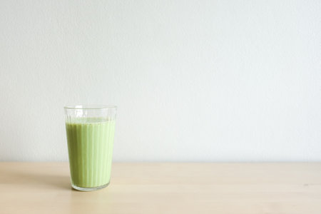Homemade iced green matcha tea and milk in glass on wooden table.の写真素材