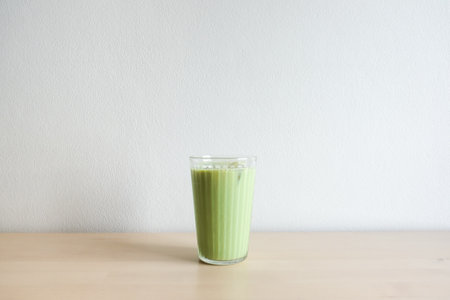 Homemade iced green matcha tea and milk in glass on wooden table.の写真素材