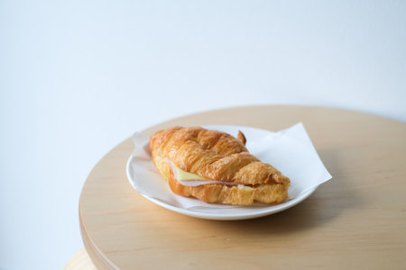 Ham cheese croissant on a white plate for breakfast.の写真素材