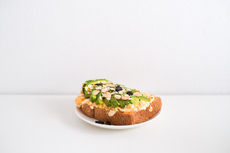 Avocado sandwich with scrambled eggs, sliced avocado and egg on toasted bread for healthy breakfast...