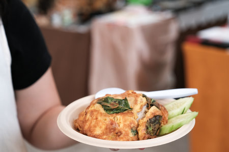 woman hand hold rice and an omelet in the market, Thailand street food.