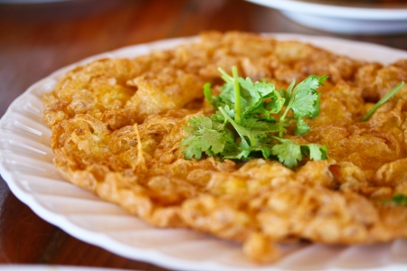 Thai style omelet on white plate and has Coriander on centerの写真素材