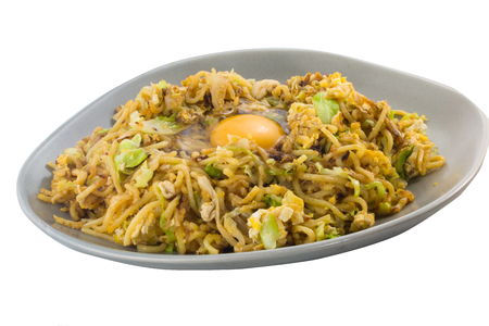 yakisoba with raw egg on plate on white backgroundの写真素材
