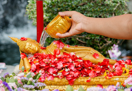 water pouring to Buddha statue in Songkran festival tradition of thailandの写真素材