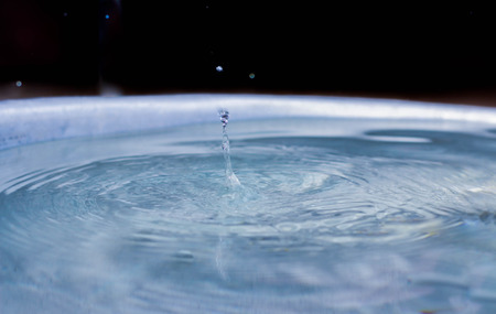 Dripping down from the roof of the house makes the water below diffuse.の写真素材