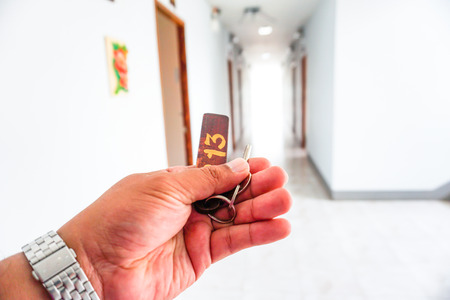 Closeup of old keyhole of room 13 with key on hand, see picture of lucky or bad.