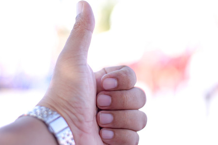 thumbs up - close up on bokeh background.の写真素材