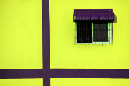 Window on the yellow wall.の写真素材