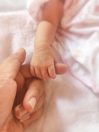 The hands of the baby and the mother