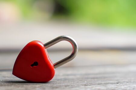 The red heart key is on a wooden table with a natural bokeh background, the concept of Valentines Day and the Day of Love.の写真素材