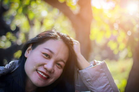 Asian women in Thailand smiling and with natural bokeh background.の写真素材