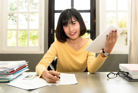 beautiful woman on the workplace using a digital tabletの写真素材