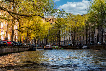 Amsterdam, Netherlands - April 15, 2015: cityscape with typical canal in Amsterdam, with unidentified people. Amsterdam is the capital and most populous city in the Netherlandsのeditorial素材