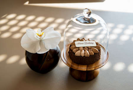 Chocolate birthday cake over a brown backgroundの写真素材