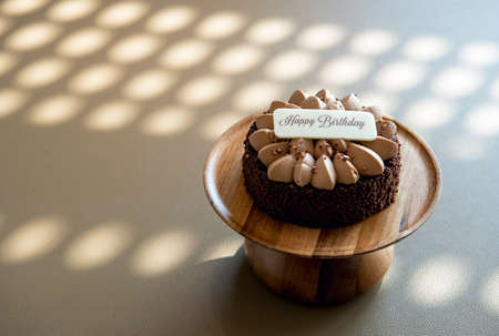 Chocolate birthday cake over a brown backgroundの写真素材