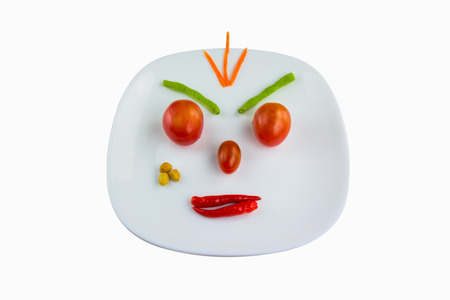 Angry face made of vegetables on the plateの写真素材