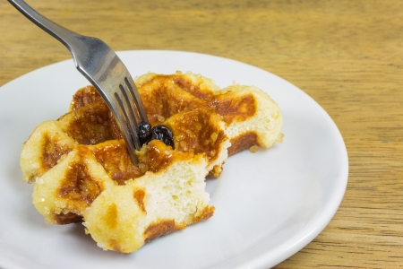 Sweet waffles with a bite missing on white plateの写真素材