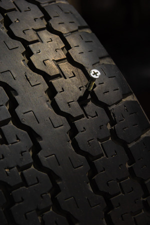 screw jammed in old tireの写真素材