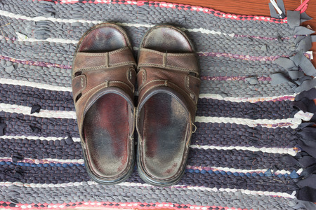 Old sandals on doormatの写真素材