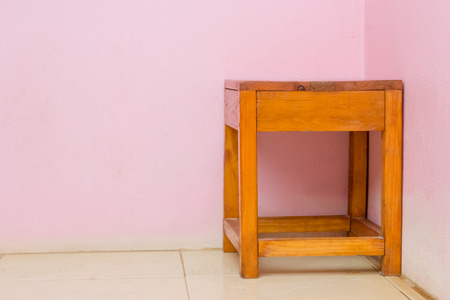 brown wooden chair with pink wallsの写真素材