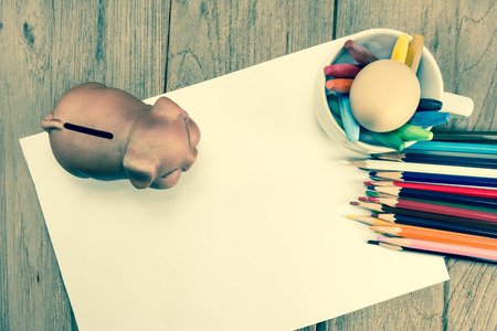 crayons and piggy bank on a sheet of paper,vintage effect filterの写真素材