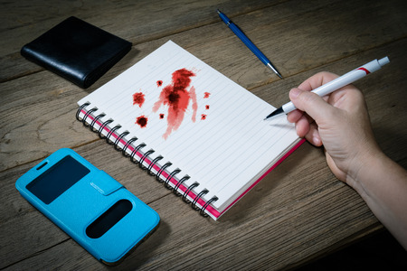 Human hand holding pen with open note book