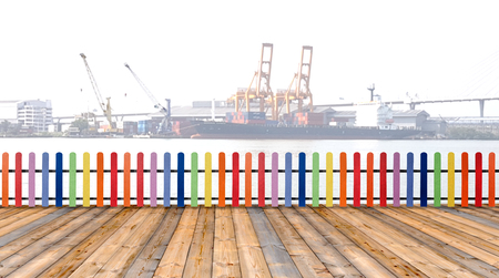 Varicolored wooden fence and floor wood with cargo ship backgroundの写真素材