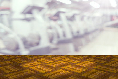 Empty wooden board space platform with blur fitness gym equipment backgroundの写真素材