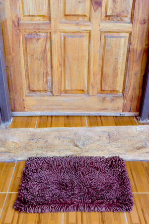 maroon door mat with close doorの写真素材