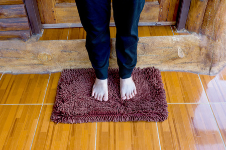 maroon doormat with female footの写真素材