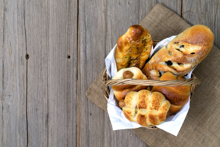 various fresh cheese sausage bread In the basket on wooden background,top viewの写真素材