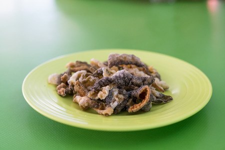 crispy fried fish skin on green dishの写真素材