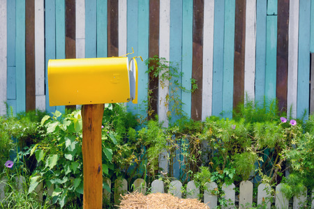 yellow vintage mailbox with wooden wall in gardenの写真素材