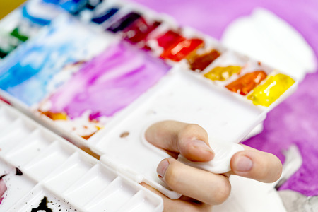 closeup hand holding colored paletteの写真素材
