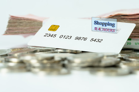 White plastic credit card with coin and banknotesの写真素材