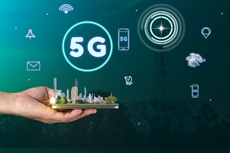 hand holding mobile smart phone with skyscraper,5G network interface and icon concept
