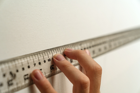 hand holding ruler with canvas background